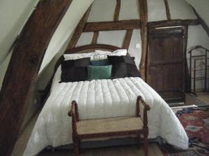 ein Schlafzimmer mit einem Bett mit einem Holzrahmen in der Unterkunft La Longère Aux Sapins in Fontaine-le-Bourg