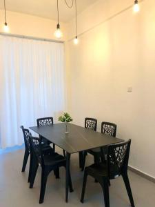a black dining room table with chairs and a vase on it at Blue House｜Ulu Yam Homestay｜12-15pax in Batang Kali