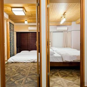 2 Betten in einem Zimmer mit offener Tür in der Unterkunft ueno minowa401 in Tokio