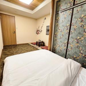 ein Schlafzimmer mit einem großen weißen Bett in einem Zimmer in der Unterkunft ueno minowa401 in Tokio