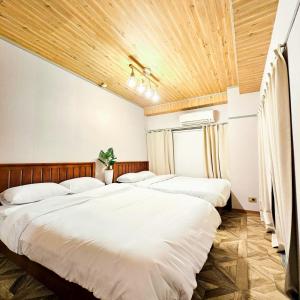 three beds in a room with wooden ceilings at ueno minowa401 in Tokyo