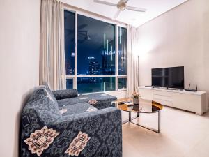 a living room with a couch and a large window at Soho Suites KLCC by Alucard's Cat in Kuala Lumpur