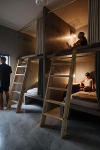a room with three bunk beds with people sitting on them at Slack BnB in Xiaoliuqiu