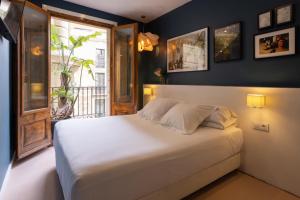 1 dormitorio con cama blanca y ventana en Hostal Sol y K, en Barcelona