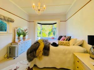 Schlafzimmer mit einem Bett und einem Kronleuchter in der Unterkunft Windhaven Bed & Breakfast in Duntroon