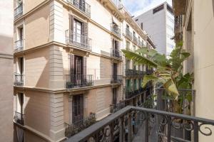 Un balcón de un edificio con ventanas y una planta en Hostal Sol y K, en Barcelona