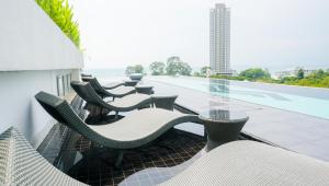 a patio with chairs and tables on a building at Mirage Condominium in Sattahip