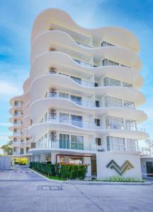a white apartment building with a curved facade at Mirage Condominium in Sattahip