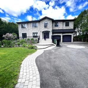 una casa grande con una entrada delante de ella en Villa Delrose Waterfront, en Montreal