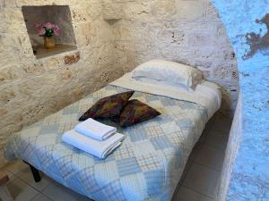 オストゥーニにあるTrullo L'ulivoのタオルが備わるドミトリールームの小さなベッド1台分です。