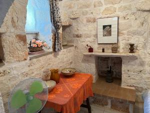 a stone room with a table and a fireplace at Trullo L'ulivo in Ostuni