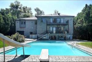 a large swimming pool in front of a house at Villa Delrose Waterfront - No party in Montreal