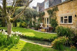 a house with a garden with a stream in the yard at Lower Mill 1 Cottage Broadway in Broadway