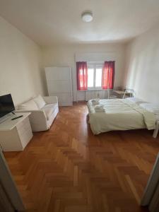 een grote kamer met 2 bedden en een bank bij La casa di Chicco in Trieste