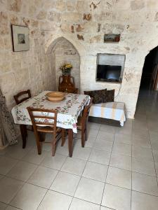 a dining room with a table and a tv at Trullo L'ulivo in Ostuni