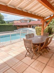 patio ze stołem i krzesłami na pokładzie w obiekcie Magnifique maison à Lentilly - Piscine w mieście Lentilly