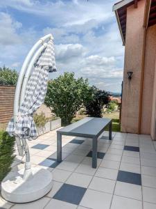 a table with a cloth on it on a patio at Magnifique maison à Lentilly - Piscine in Lentilly