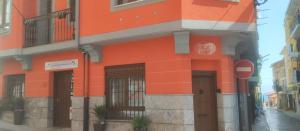 un edificio naranja en una calle con una señal de stop en Andra Mari Apartamentu Turistikoak, en Bermeo