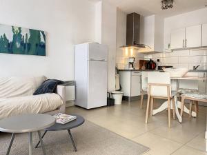 a living room with a couch and a table and a kitchen at Appartement Cucq-Stella Plage, 3 pièces, 4 personnes - FR-1-236-149 in Cucq