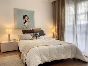 a bedroom with a large bed with a painting on the wall at Appartement Cucq-Stella Plage, 3 pièces, 4 personnes - FR-1-236-149 in Cucq