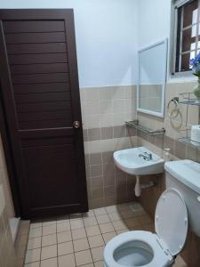 a bathroom with a toilet and a sink and a mirror at Casablanca Holiday Home with BBQ Pit in Kuching