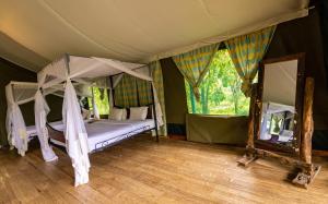 a bedroom with a canopy bed and a mirror at Ngorongoro Wild Camp in Ngorongoro