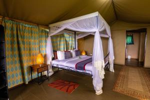 a bedroom with a canopy bed in a tent at Ngorongoro Wild Camp in Ngorongoro