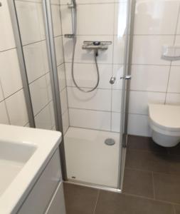 ein Bad mit einer Dusche, einem Waschbecken und einem WC in der Unterkunft Maje Am alten Binnenhafen in Emden