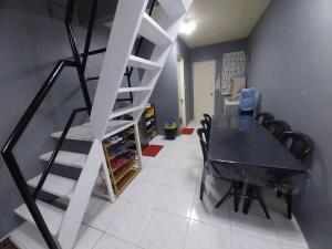 a dining room with a table and a staircase at Balanga Prime King Staycation 1 in Santa Rosa