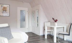 Sala de estar blanca con mesa y cama en Sonnenblumenhaus 02, en Prerow