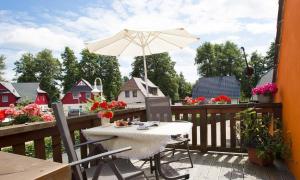 a table with an umbrella on a wooden deck at Sonnenblumenhaus 02 in Prerow