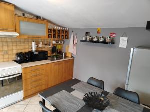 a kitchen with a table and a refrigerator at Domov Carlotka in Bratislava