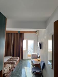 a hotel room with a bed and a desk and a chair at Vila Jolie in Costinesti