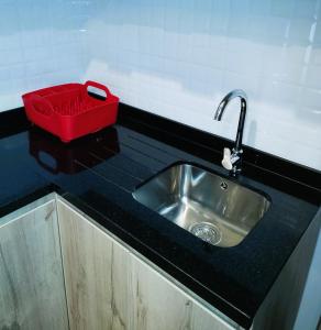 a kitchen counter with a sink and a red box on it at LA POSADA de GUILLE 2 in Lima