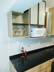 a kitchen counter with wine glasses and a microwave at LA POSADA de GUILLE 2 in Lima