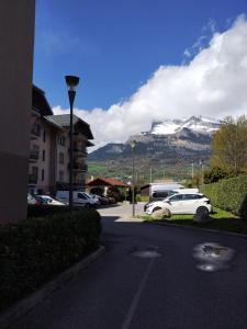 a white car parked in a parking lot with a mountain at Thermalines in Saint-Gervais-les-Bains