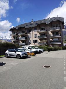 a parking lot with cars parked in front of a building at Thermalines in Saint-Gervais-les-Bains