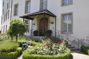 BnB SchlafSchloss في Sumiswald: البيت الأبيض مع الزهور أمامه