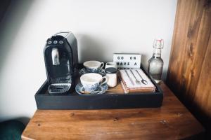 a coffee maker and cups on a wooden table at Modern Penthouse Apartment in Cobh Town in Cobh