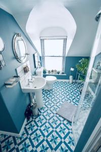 Baño azul con lavabo y aseo en Modern Penthouse Apartment in Cobh Town, en Cobh