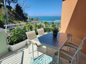 una mesa y sillas en un balcón con vistas al océano en Le Sfumature del Mare, en San Vito Chietino