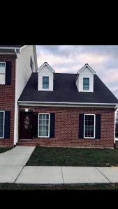 una casa de ladrillo rojo con techo negro en MooreField Suites Greensboro East, en McLeansville