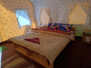 - une chambre avec un grand lit dans l'établissement Baspa Valley Adventure Camp, à Saturang