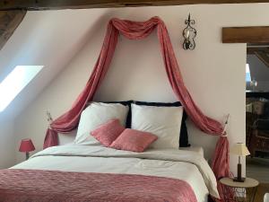 a bedroom with a bed with a red canopy at Un bijou au cœur de Belleme in Bellême