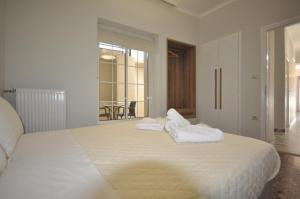een slaapkamer met een groot wit bed en handdoeken bij Apartments Chania in Chania
