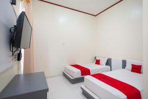 En eller flere senge i et værelse på RedDoorz Syariah near RS Tentara Solok