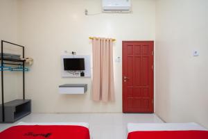 SolokにあるRedDoorz Syariah near RS Tentara Solokのリビングルーム(赤いドア、テレビ付)
