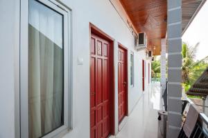 SolokにあるRedDoorz Syariah near RS Tentara Solokの赤い扉のある廊下