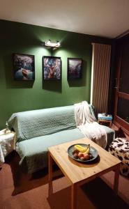 a room with a bed and a table with a bowl of fruit at Appartement cosy cœur de station in Villard-de-Lans