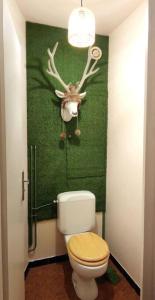 a bathroom with a toilet with a deer head on the wall at Appartement cosy cœur de station in Villard-de-Lans